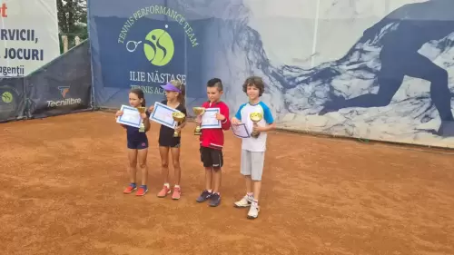 Patru tineri jucători de tenis țin în mâini diplomele și trofeele câștigate după un turneu
